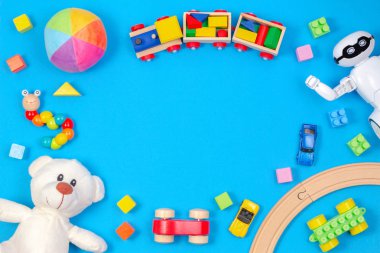 Çocuklar oyuncak arka plan. Beyaz oyuncak ayı, ahşap tren, oyuncak araba, robot, açık mavi renkli renkli bloklar