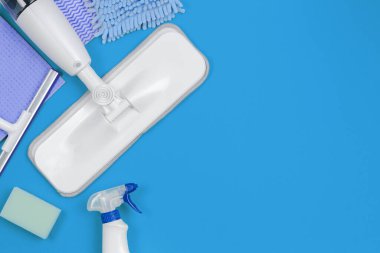 Housework, housekeeping, household, cleaning service concept. Cleaning spray mop with rags and sponges on blue background clipart