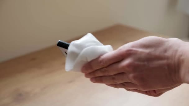Vrouwelijke hand schoon mobiele telefoon met antibacteriële natte veeg. Vrouw schoonmaken en desinfecteren mobiele telefoon thuis — Stockvideo