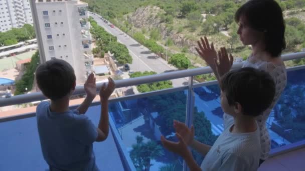 Familie applaudiert vom Balkon, um medizinisches Personal, medizinisches Personal, Ärzte und Krankenschwestern während der Coronavirus-Pandemie in Spanien zu unterstützen — Stockvideo