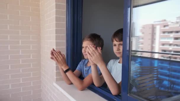 Aplausos al personal médico. Niños aplaudiendo de la mano, aplaudiendo desde la ventana para apoyar a médicos, enfermeras, trabajadores hospitalarios durante la cuarentena pandémica del Coronavirus — Vídeo de stock