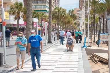 Benidorm, İspanya, 14 Haziran 2020: İnsanlar Benidorm Levante sahilinde güneşli bir günün tadını çıkarıyorlar. Coronavirus salgınından sonra popüler İspanyol tatil beldesi