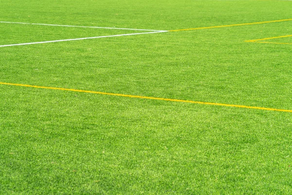 Groene kunstgras gras voetbal voetbalveld achtergrond met witte en gele lijn grens. Bovenaanzicht — Stockfoto