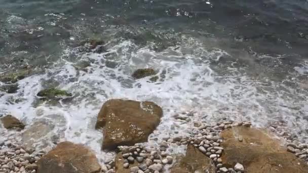 Cerca de guijarros de playa rocosa en la orilla y olas de mar onduladas salpicaduras — Vídeo de stock