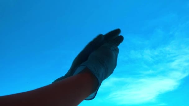 Vrouw handen met beschermende handschoenen applaudisseren over blauwe lucht achtergrond tijdens Coronavirus Pandemische quarantaine — Stockvideo
