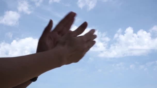 Tapsot! Női kéz tapsol a kék égbolt hátterében. Alacsony látószög — Stock videók