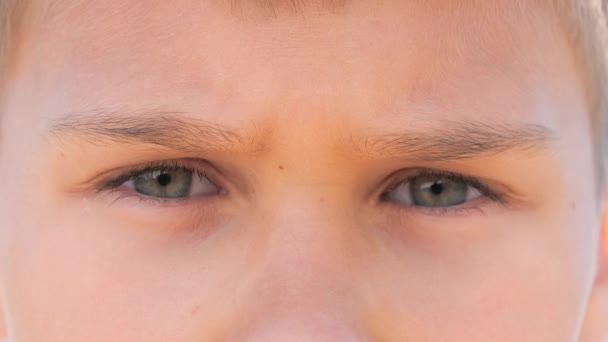 Adoráveis olhos de menino olha para a câmera. Vídeo 4K. Fechar — Vídeo de Stock