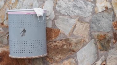 Yüz maskeleri şehrin sokaklarını kirletiyor. Dışarıdaki çöp kutusunda koruyucu yüz maskesi kullanmış. Çevre kirliliği