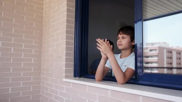 Діти плескають в долоні, аплодують з вікна, щоб підтримати лікарів, медсестер, працівників лікарень під час карантину. — стокове відео