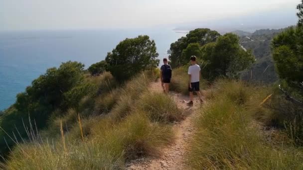 Deux enfants marchant dans un parc naturel près de la mer Méditerranée en Espagne et profitant de la belle journée ensoleillée — Video
