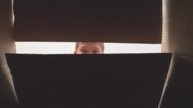 Kutuda sürpriz var. Genç çocuk kutuyu aç, hediye aldığına sevindi. İnternetten alışveriş, teslimat, doğum günü, Noel hediyesi kutusu. 4k video