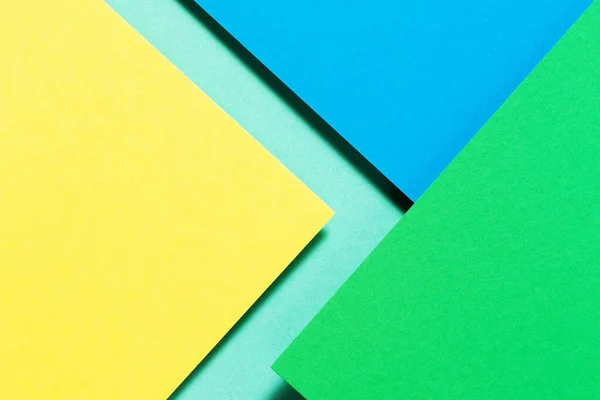 Abstrakt färg papper geometri platt låg sammansättning bakgrund med blå, gul och grön färg toner — Stockfoto