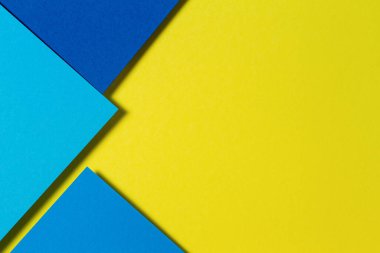 Soyut renk kağıtları geometri düz kompozisyon arka planı mavi ve sarı tonlarla