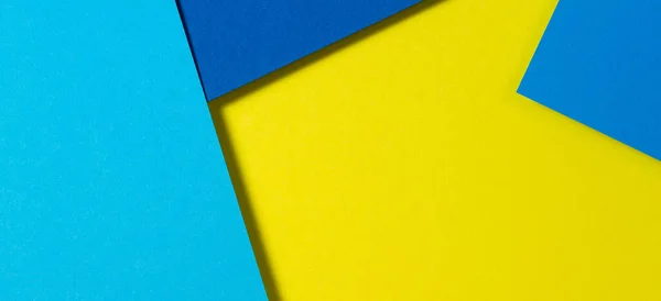 Abstrakt färg papper geometri platt låg sammansättning bakgrund med blå och gula toner — Stockfoto