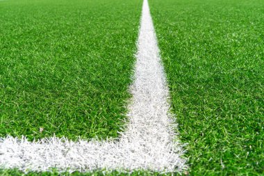 Beyaz çizgili yeşil çimenli futbol sahası arka planı. Üst görünüm