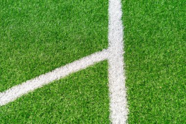Beyaz çizgili yeşil çimenli futbol sahası arka planı. Üst görünüm