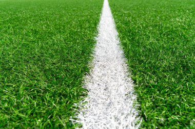 Beyaz çizgili yeşil çimenli futbol sahası arka planı. Üst görünüm
