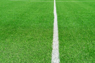 Yeşil yapay çimen sahası futbol sahası arka planı ve beyaz orta çizgisi. Üst görünüm