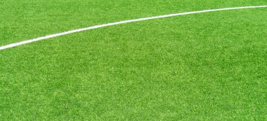 Yeşil yapay çim futbol sahası arka planında beyaz çizgiler var. Üst görünüm