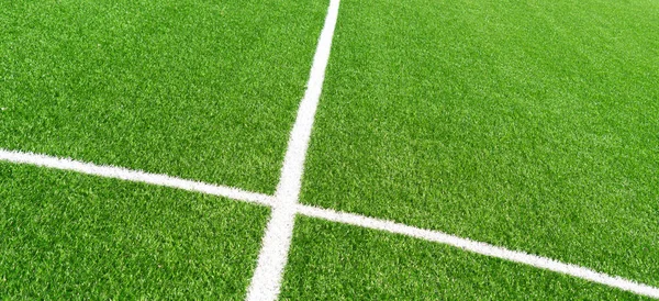 Зеленый искусственный газон футбольное поле футбольное поле с белыми линиями. Вид сверху — стоковое фото