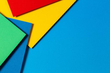 Soyut renk kağıtları geometri düz kompozisyon arkaplan mavi, sarı, yeşil ve kırmızı renk tonlarıyla