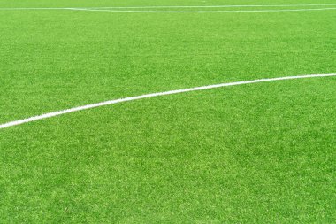 Yeşil yapay çim futbol sahası arka planında beyaz çizgiler var. Üst görünüm
