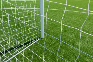 Futbol kapılarını beyaz ağ ve yeşil çimen arka planıyla kapatın