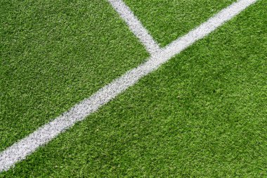 Beyaz çizgili yeşil çimenli futbol sahası arka planı. Üst görünüm