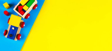 Açık mavi ve sarı arka planda renkli blokları olan tahta oyuncak tren. Üst görünüm