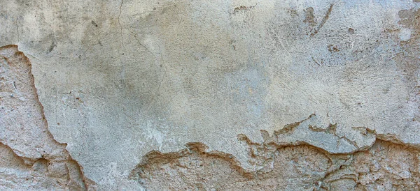 Old cracked weathered painted wall background texture. Light peeled plaster wall with falling off flakes of paint — Stock Photo, Image