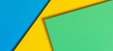 Soyut renk kağıtları geometri düz kompozisyon pankart arka planı mavi, sarı ve yeşil renk tonlarıyla