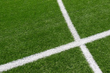 Beyaz çizgili yeşil çimenli futbol sahası arka planı. Üst görünüm