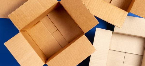 Порожні відкриті картонні коробки на синьому фоні. Вид зверху — стокове фото