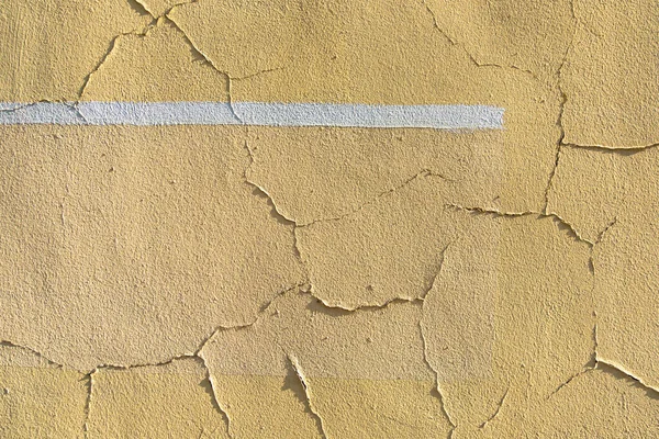 Vieille texture de fond peinte et fissurée. Mur de couleur jaune avec ligne blanche. — Photo
