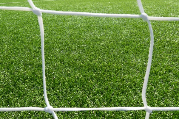 Gros plan du filet de but de football de football avec fond d'herbe verte — Photo