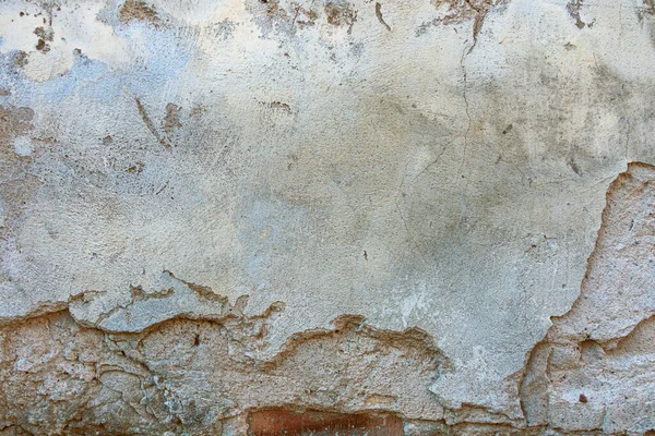 古い割れた風化した壁の背景のテクスチャ。塗装のフレークが落ち光剥がれた石膏壁 — ストック写真