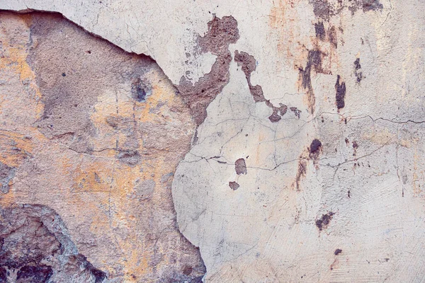 Textura de fondo de pared pintada envejecida agrietada vieja. Pared de yeso pelado ligero con escamas de pintura que se caen — Foto de Stock