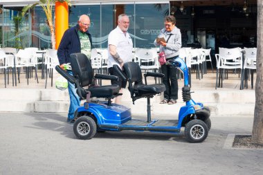 Benidorm, İspanya - Benidorm City açık hava kafede tatilciler ve engelli scooter 'ı