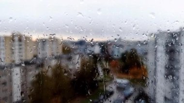 Cama düşen su damlalarının yakın görüntüsü. Pencerede yağmur yağıyor. Yağmur mevsimi, sonbahar. Yağmur damlaları damlıyor. Şehir arkaplanı