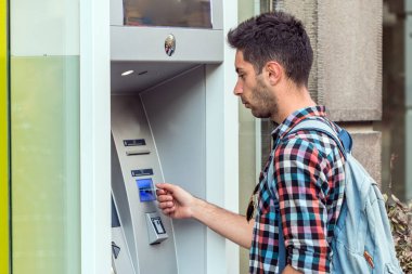 Genç adam kredi kartını şehirdeki bir bankamatiğe koymuş..