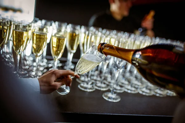 Sparkling wine is poured into a glass at a party