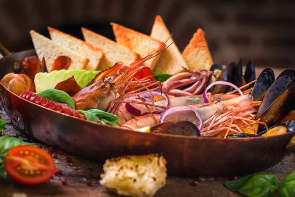 Mariscos cocidos en una sartén con tostadas y verduras — Foto de Stock