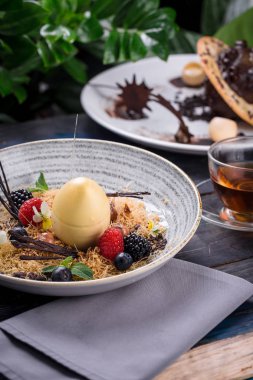 bir fincan çay ile ahşap bir masada vanilya panna cotta