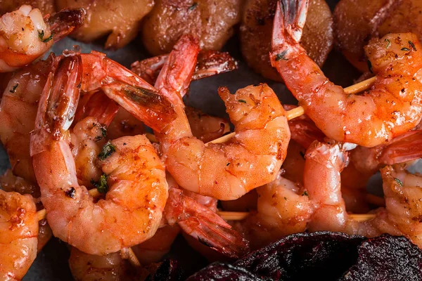 grilled shrimp skewers on a dark background