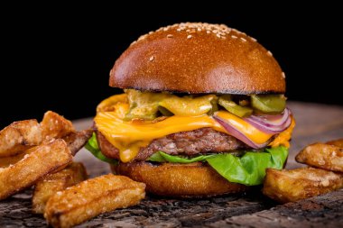 tahta bir tahta üzerinde patates kızartması ile cheeseburger