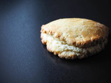 Siyah arka planda kaymaklı ev yapımı kurabiyeler.