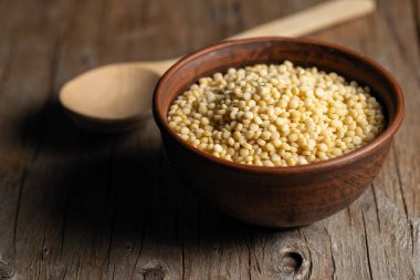 Tahta bir arka planda kilden bir kasede kuskus boğmacası.