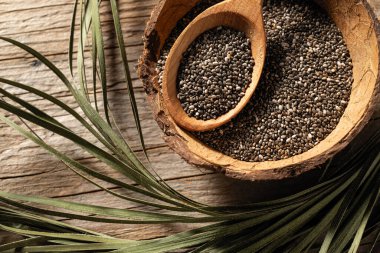 Tabaklardaki chia tohumları ahşap arka planda, yukarıdan görünüm