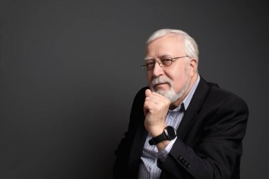 İş adamı, gri saçlı, arka planda ciddi bir şekilde...