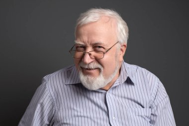 İş adamı, gri saçlı, arka planda ciddi bir şekilde...